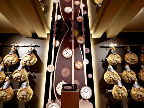 Installazione con prosciutti e orologi del museo della salumeria Villani