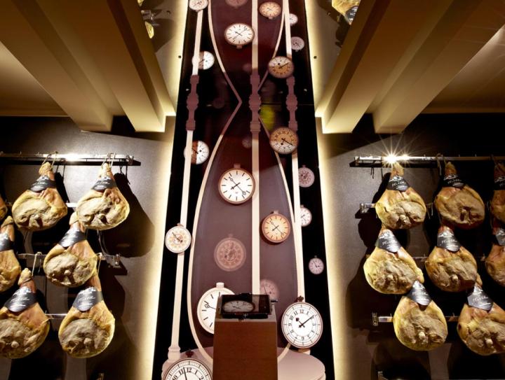 Installazione con prosciutti e orologi del museo della salumeria Villani